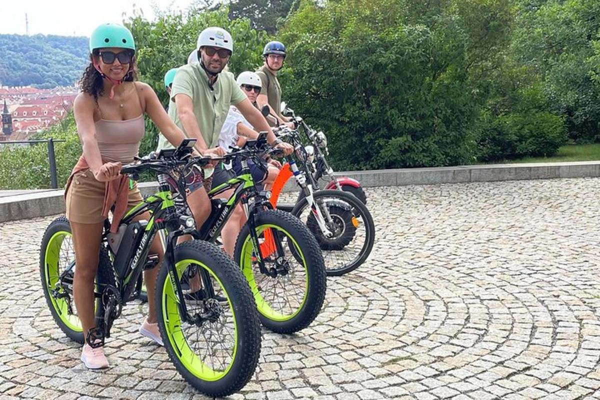 eine Gruppe von Menschen, die auf einer Ziegelsteinstraße Fahrrad fahren