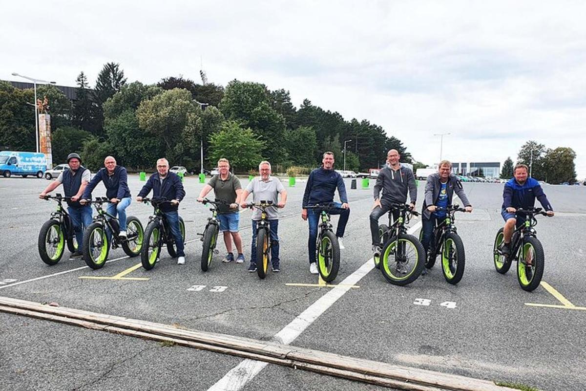 eine Gruppe von Männern auf Fahrrädern auf einem Parkplatz