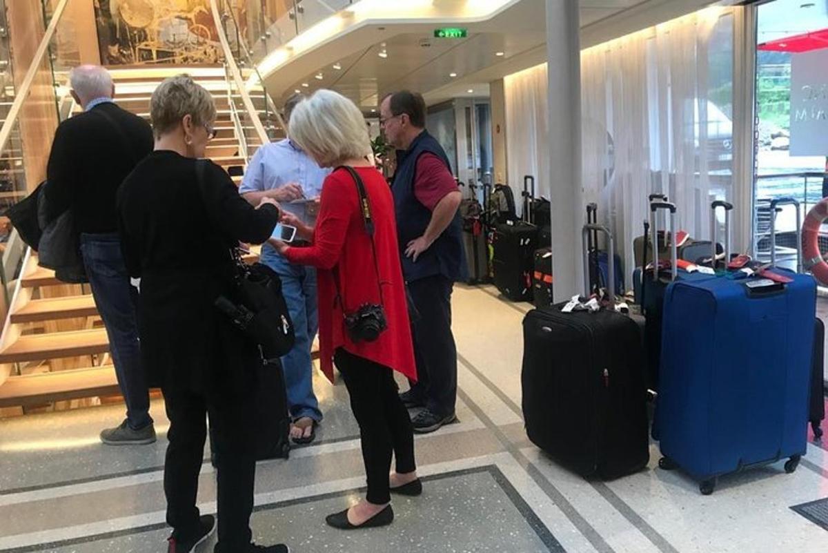 skupina lidí čekajících na svá zavazadla na letišti