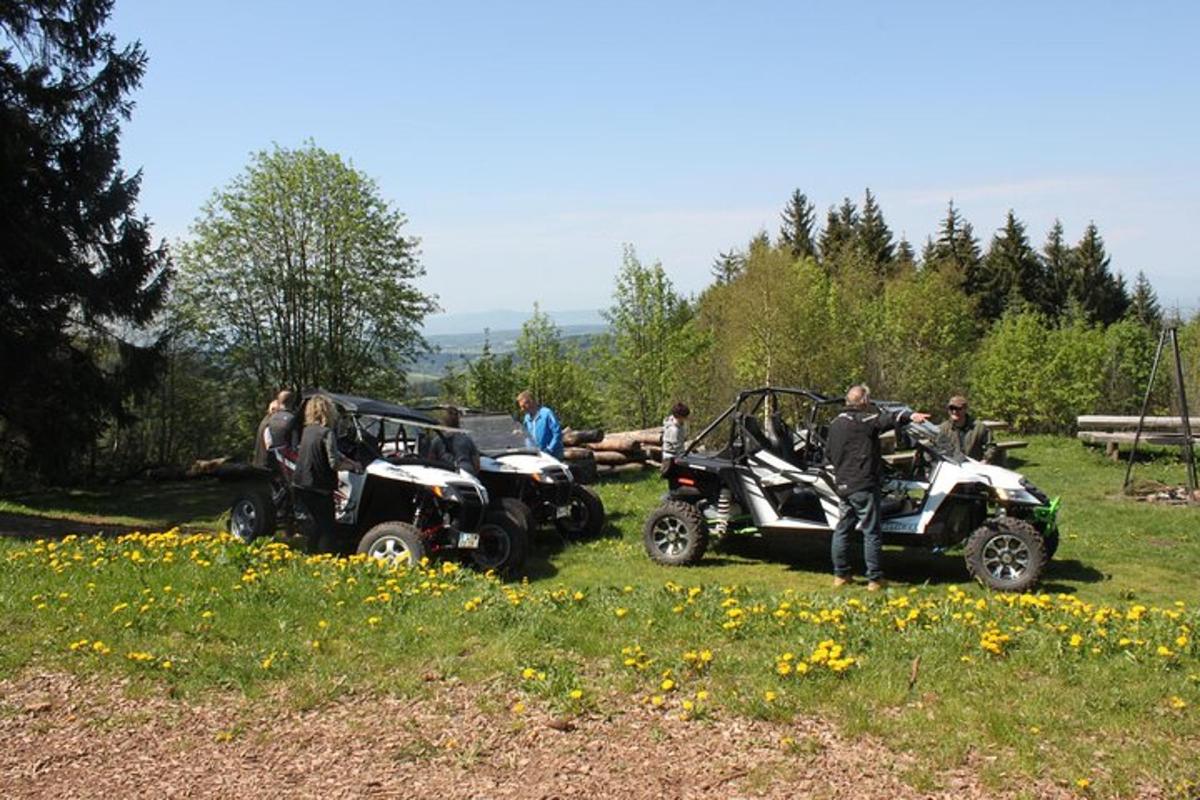 a group of people standing in a field with atvs