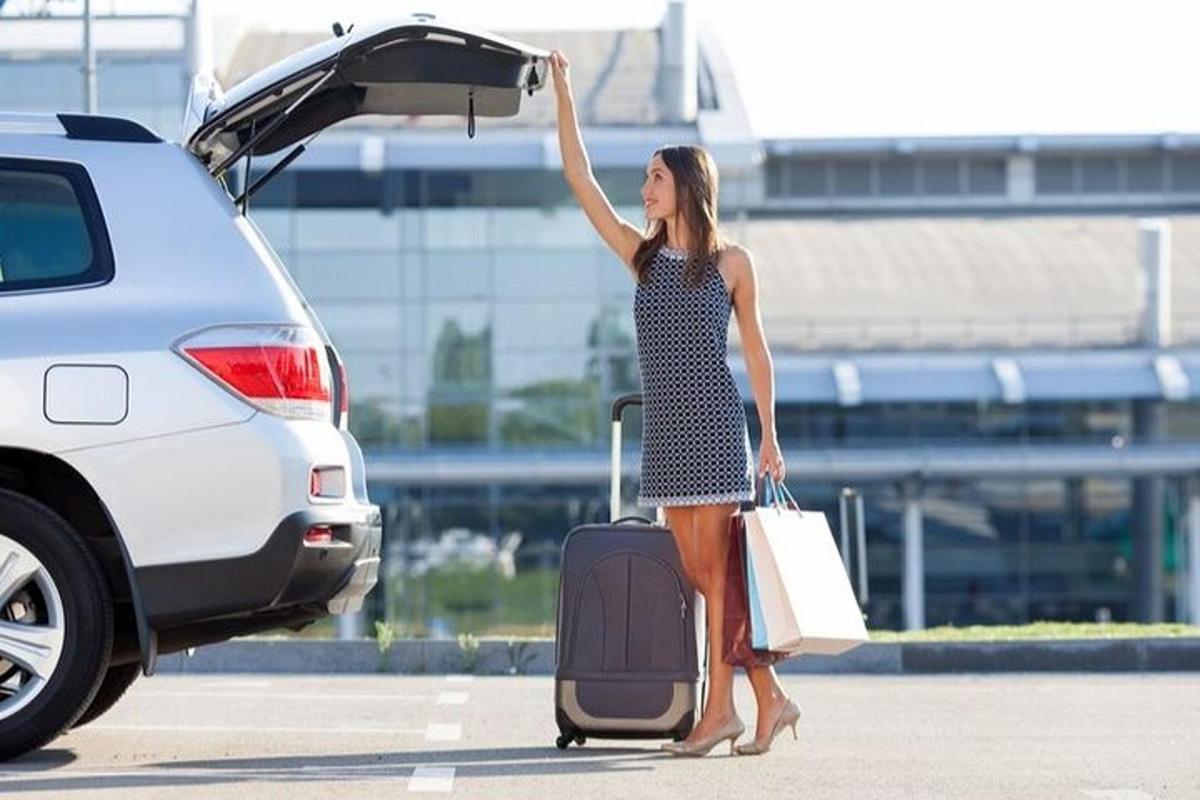 a woman with her luggage getting out of a car