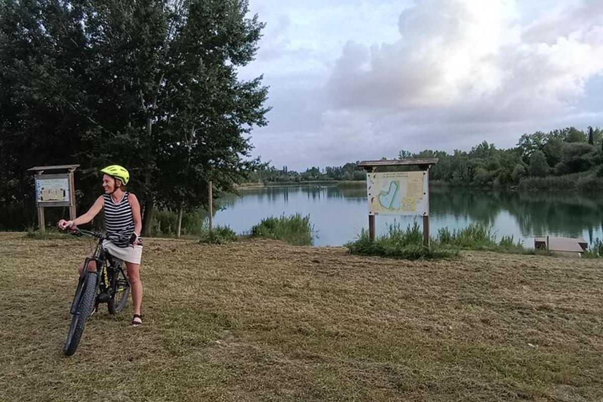 kobieta jadąca na rowerze obok jeziora
