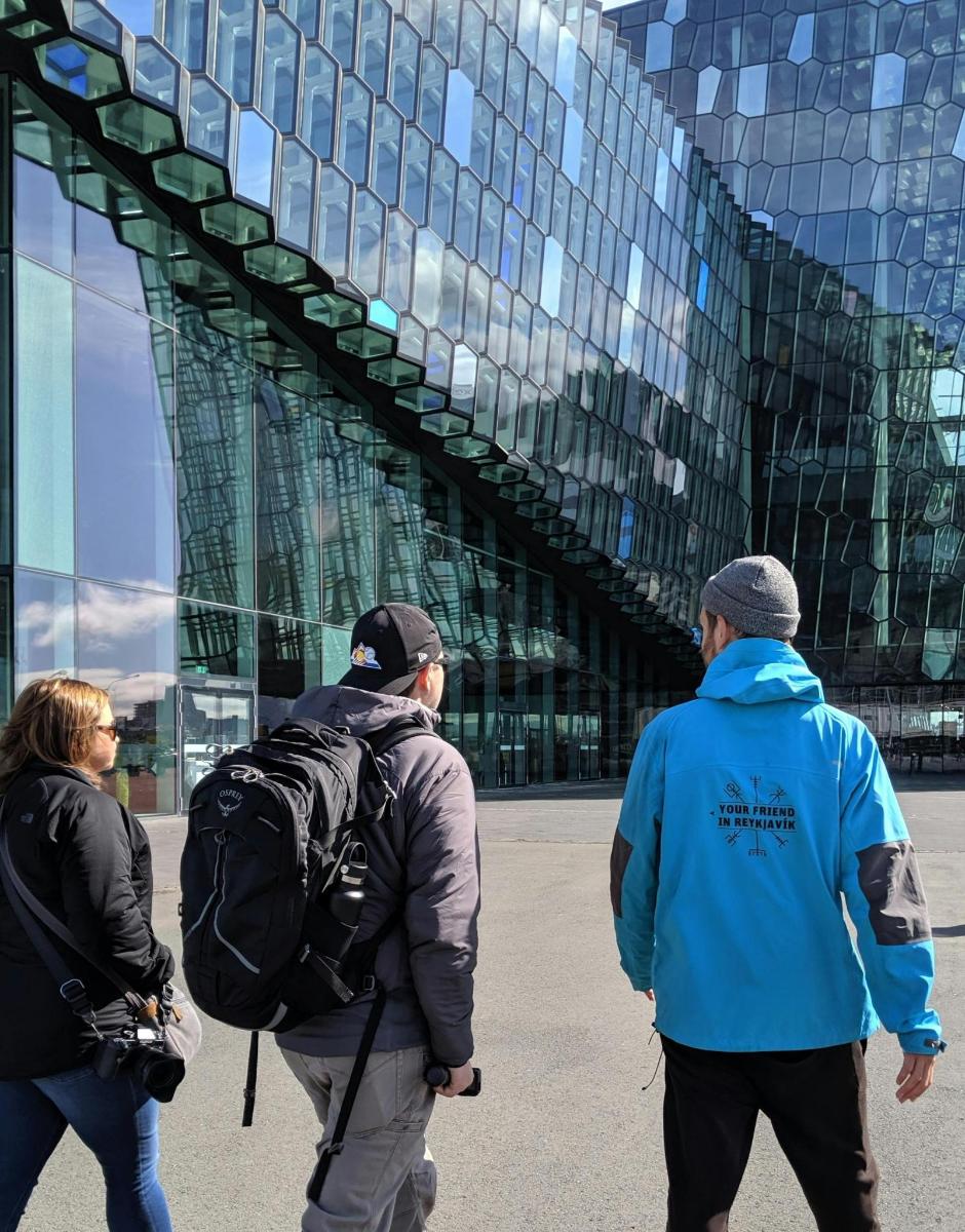 Tre personer går foran en glasbygning