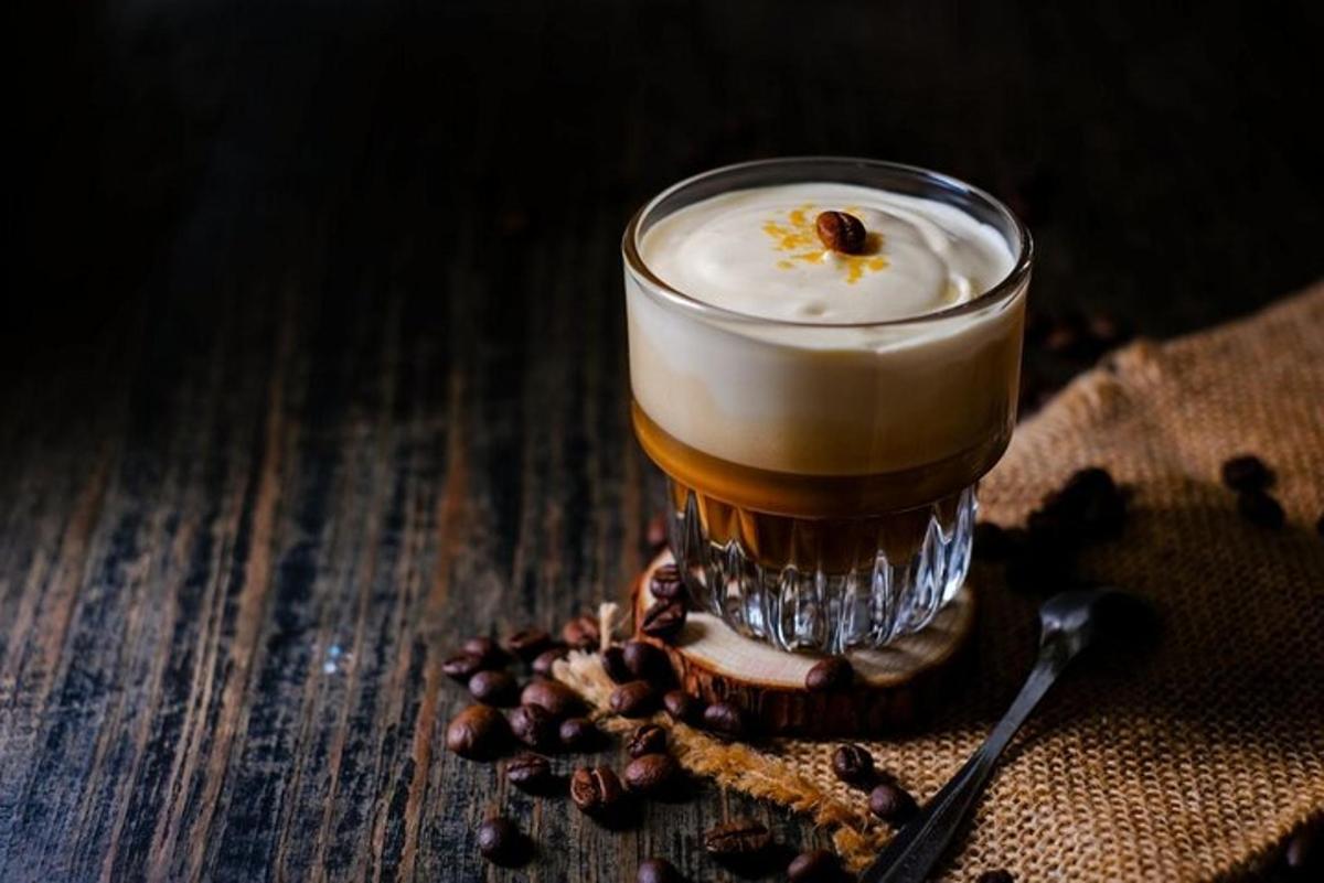 un got de cervesa assegut sobre una taula amb grans de cafè