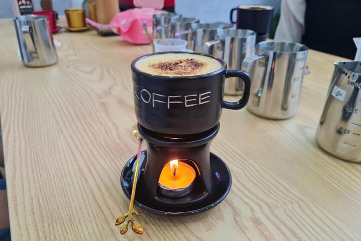 una tassa de cafè sobre una taula amb una espelma a dins