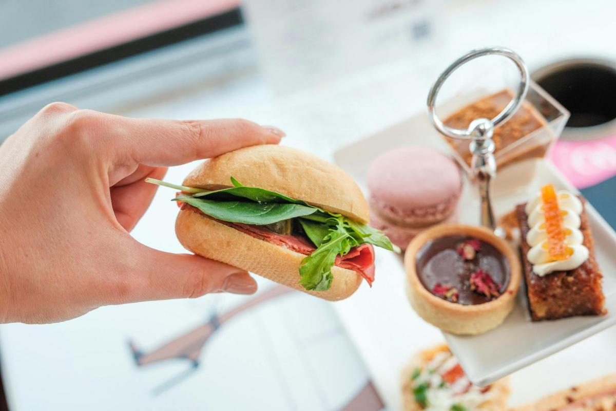 una persona tiene in mano un panino su un piatto