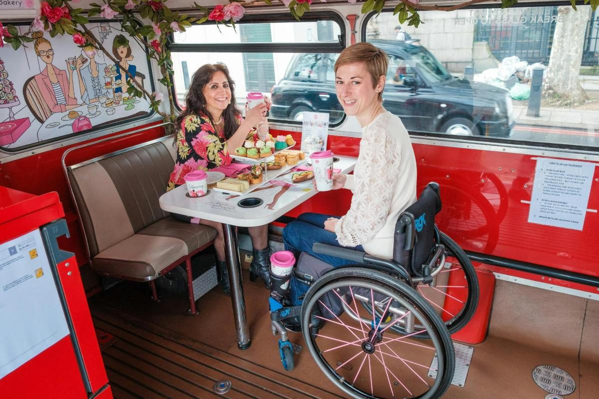un bărbat într-un scaun cu rotile așezat la o masă într-un food truck