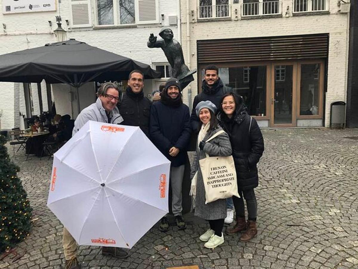 a group of people posing for a picture with an umbrella