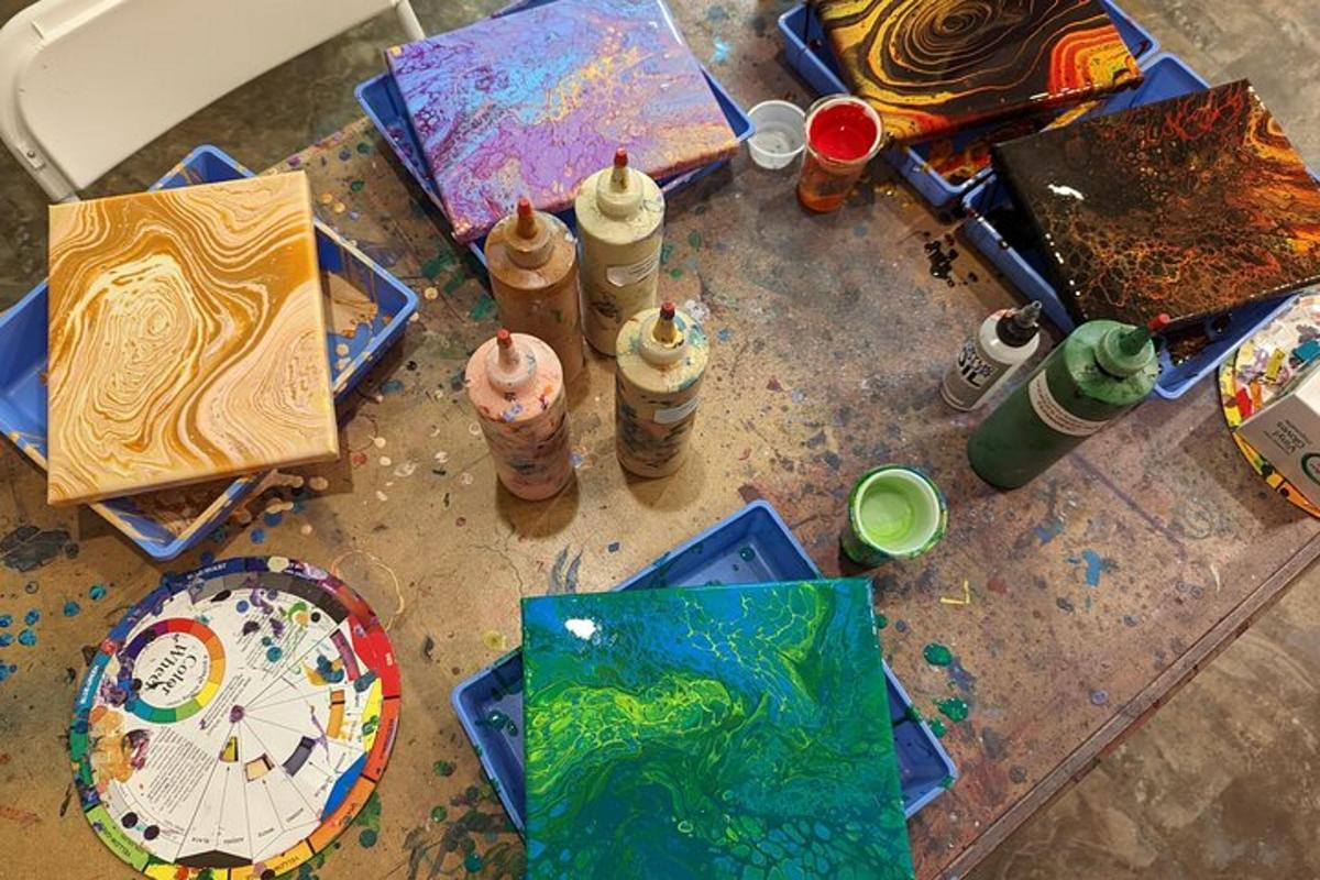 a table topped with paintings and art supplies