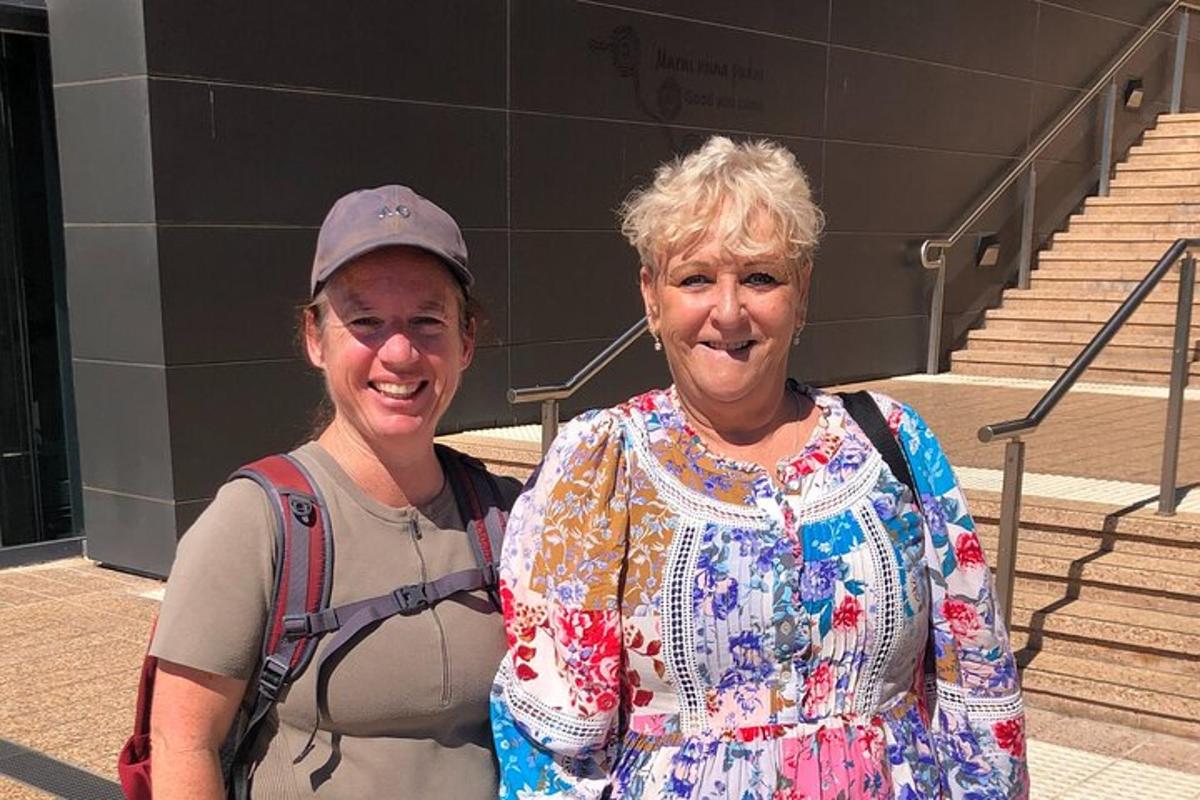 two older women standing in front of some stairs