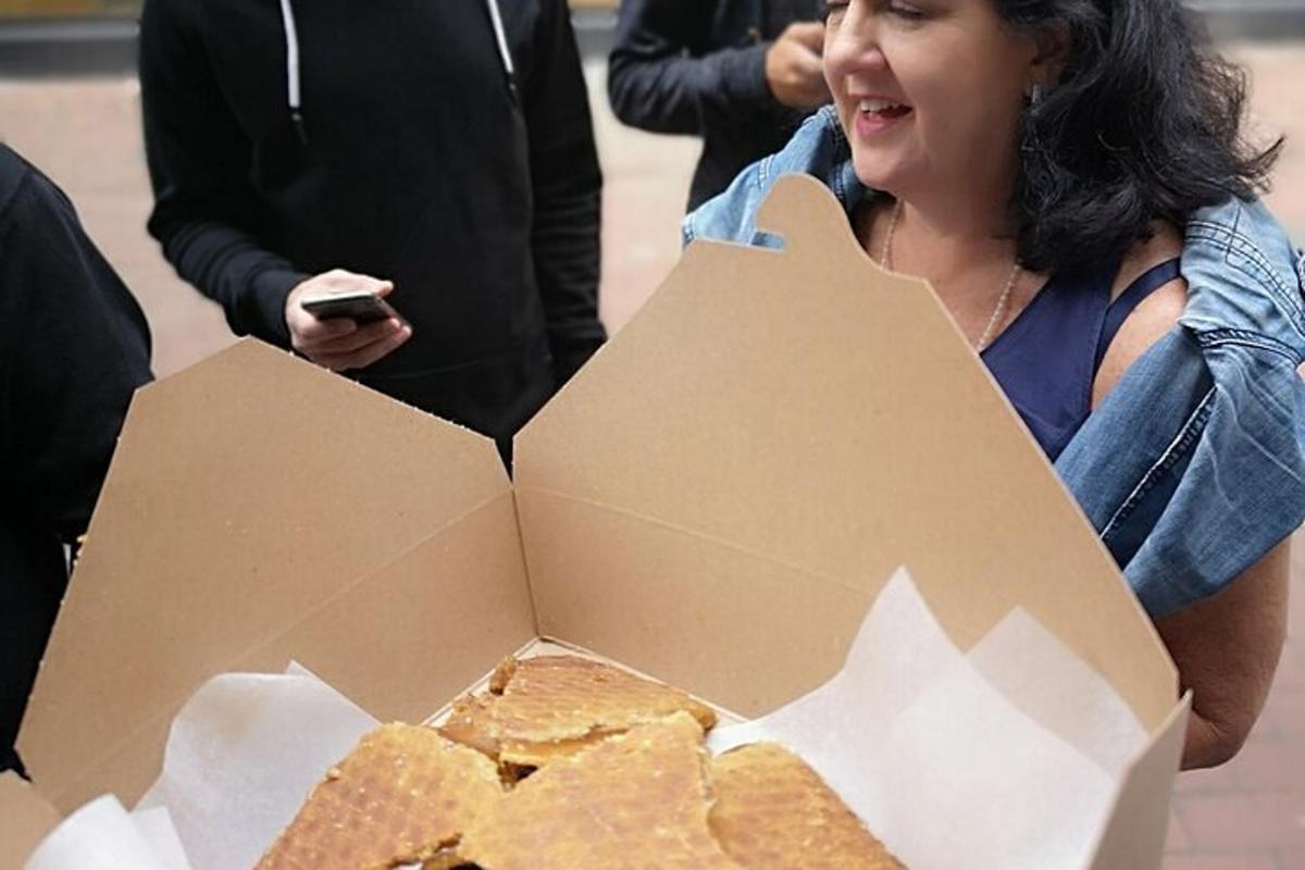 μια γυναίκα που κάθεται δίπλα σε ένα κουτί με πατατάκια