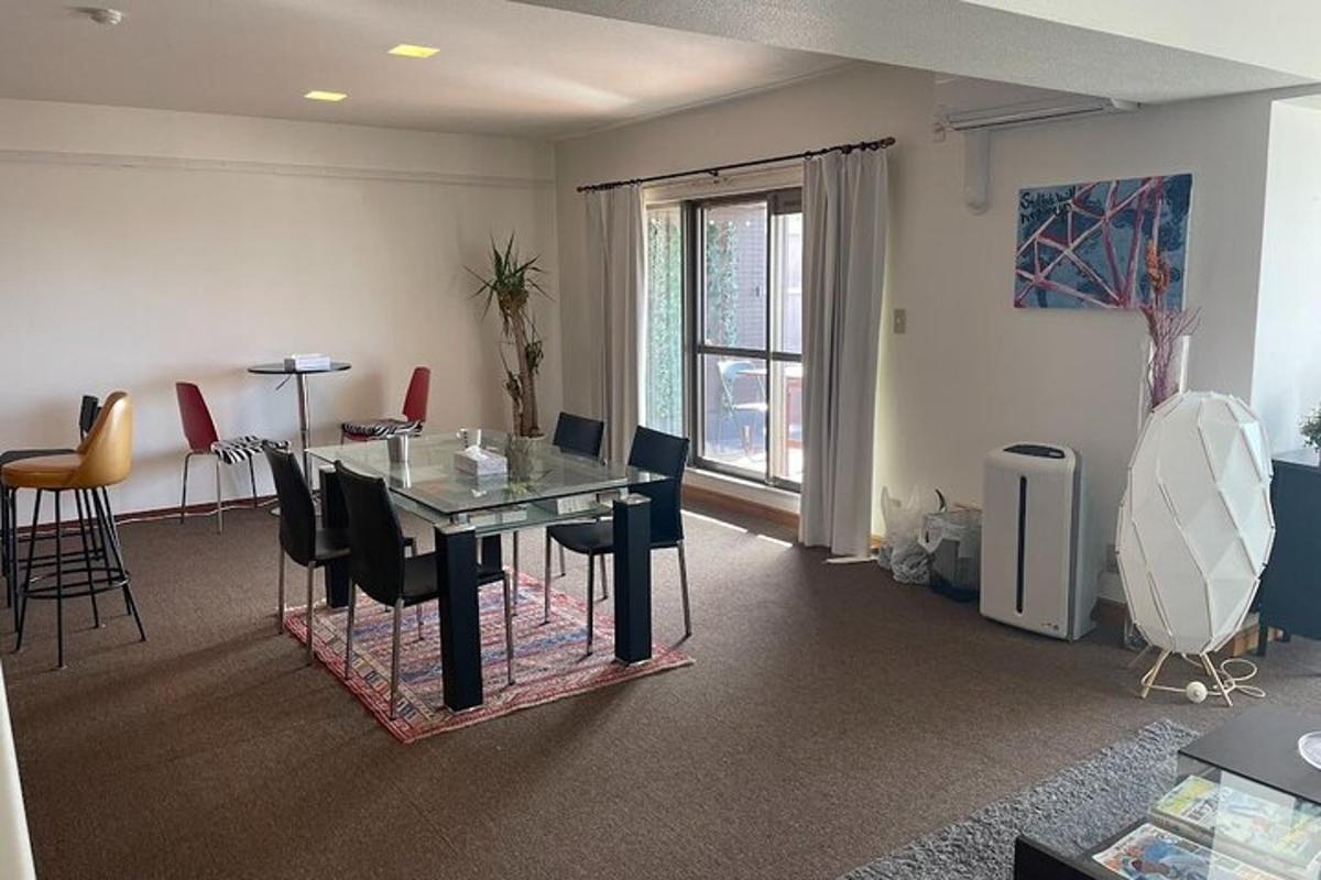 een eetkamer met een glazen tafel en stoelen