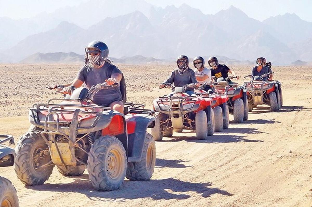 a group of people riding atvs in the desert