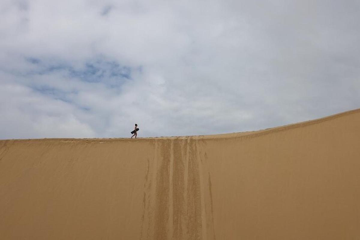 a person standing on top of a large sand ramp
