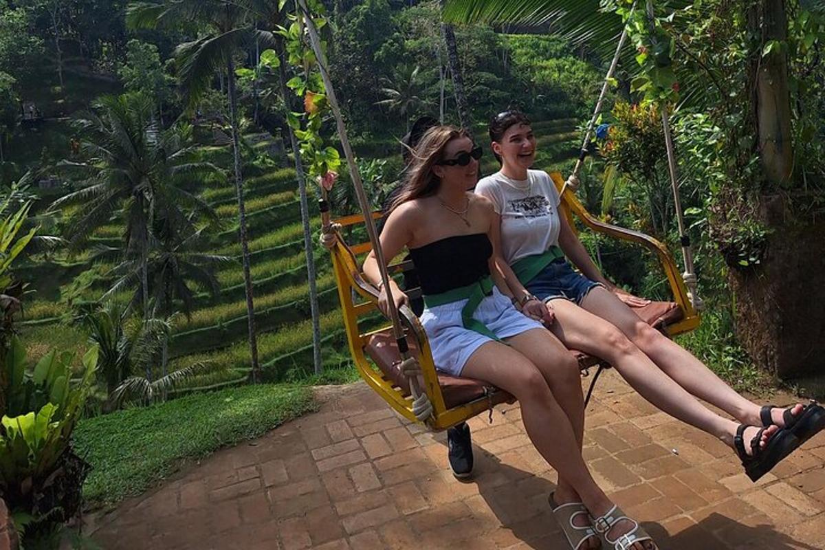 two young people sitting on a swing