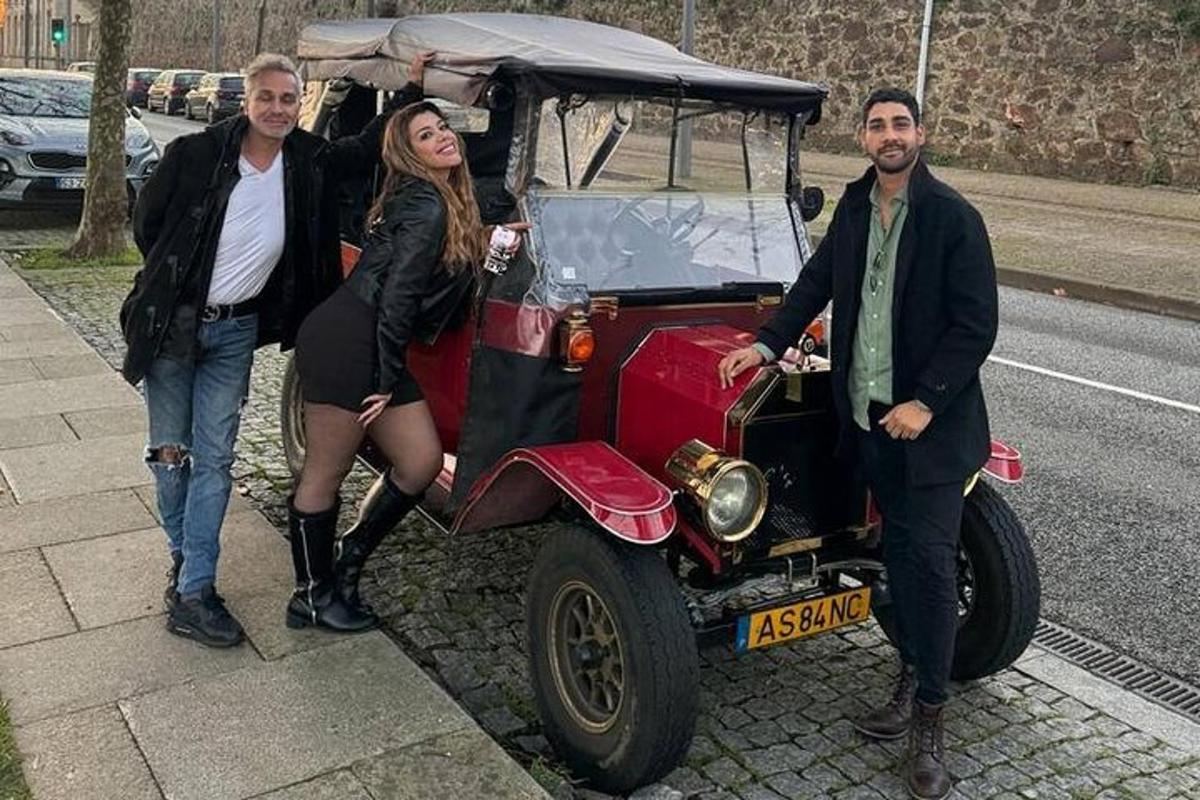 skupina lidí stojící vedle červeného auta