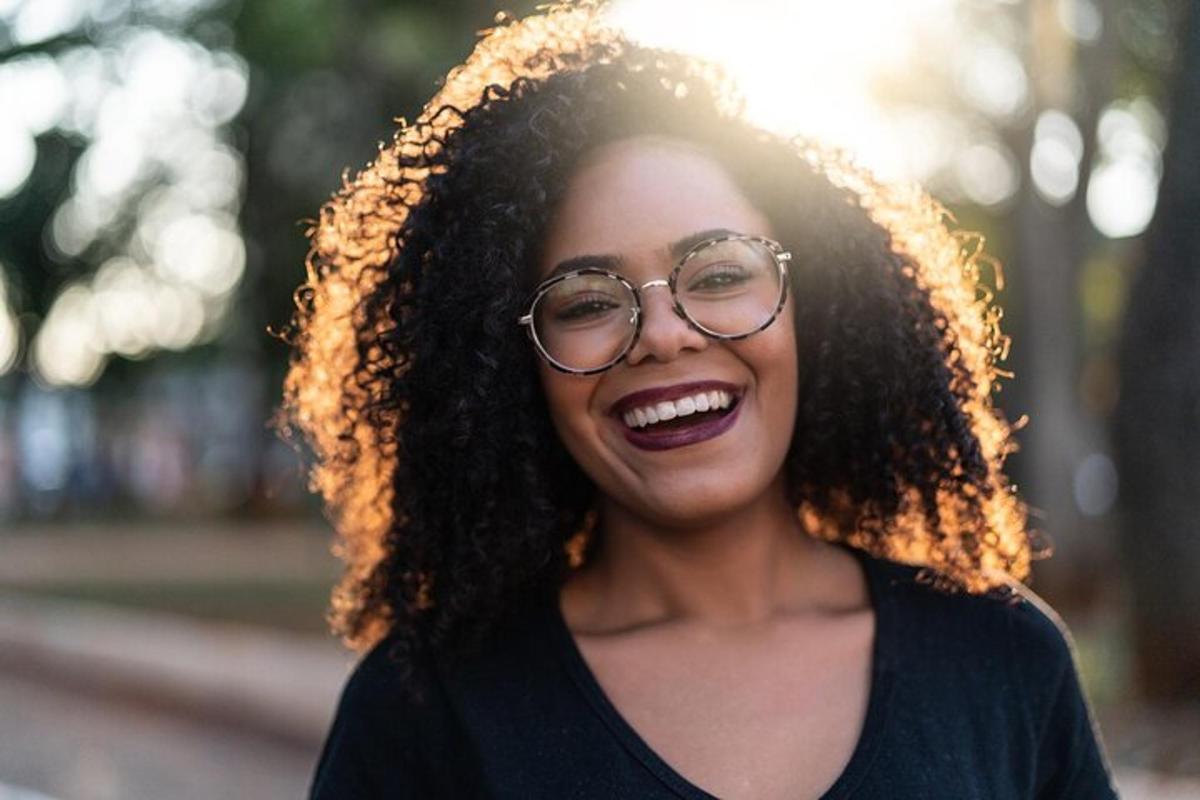 uma mulher de óculos está sorrindo e rindo