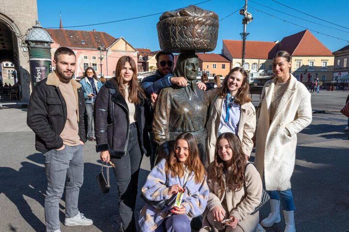 skupina ljudi, ki stojijo pred kipom