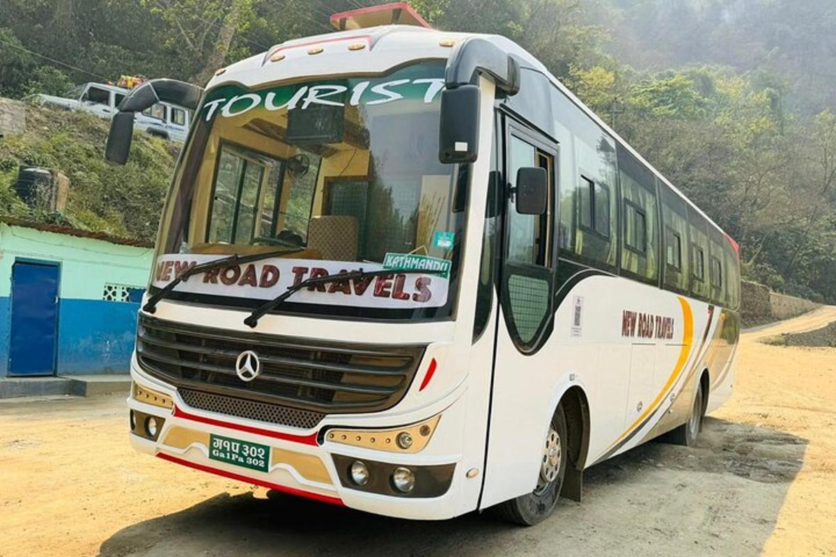 bílý autobus zaparkovaný na prašném parkovišti