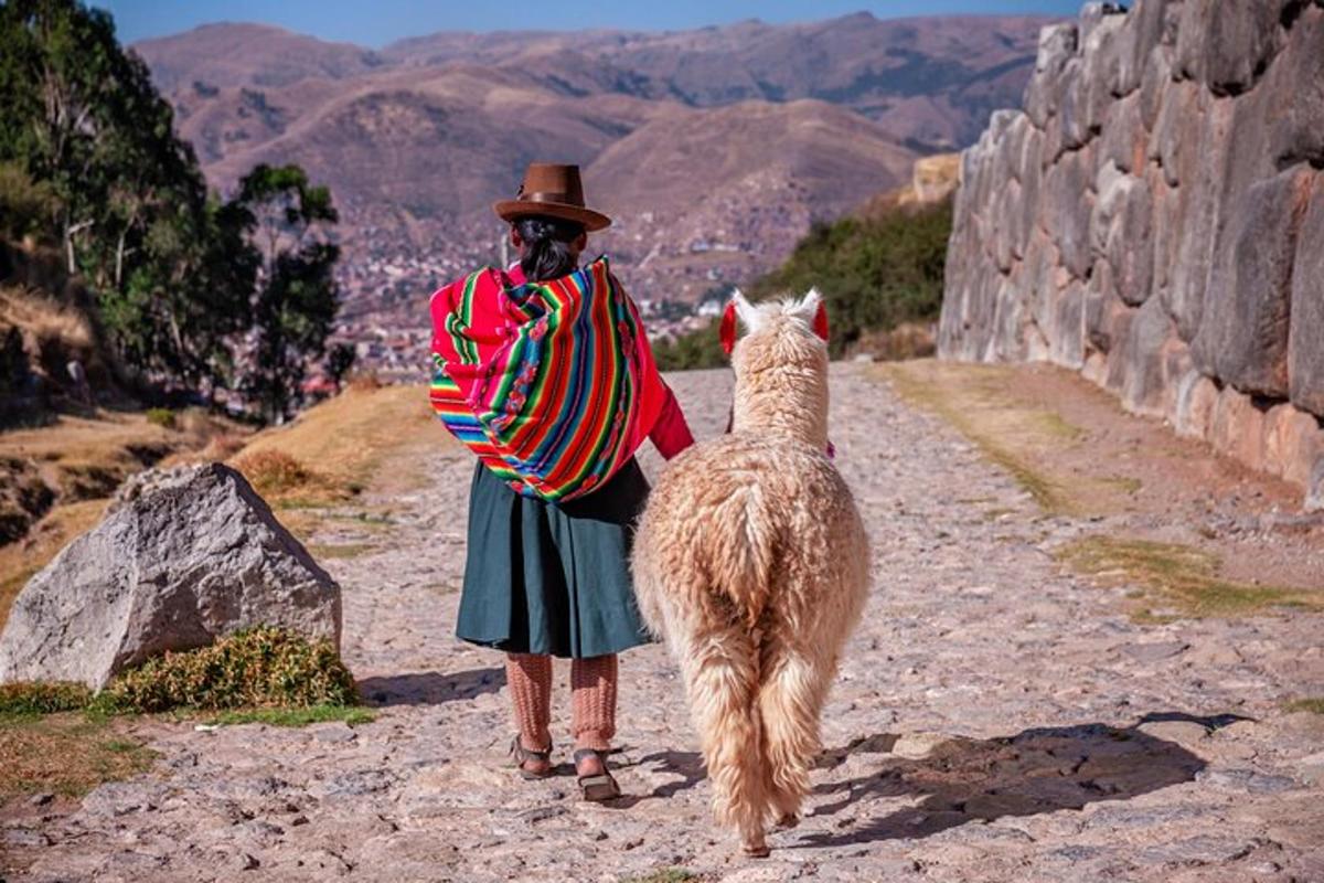 eine Frau steht neben einem Lama auf einem Berg