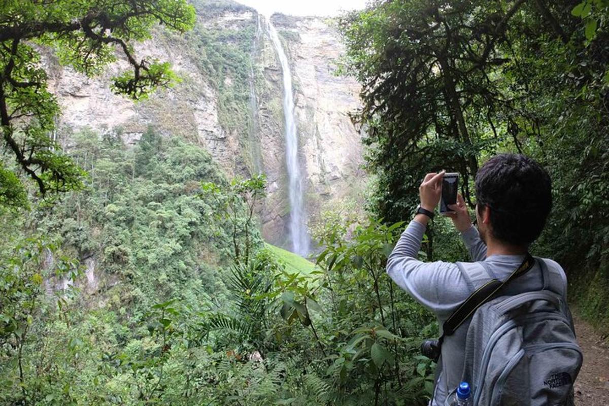 a man taking a picture of a waterfall