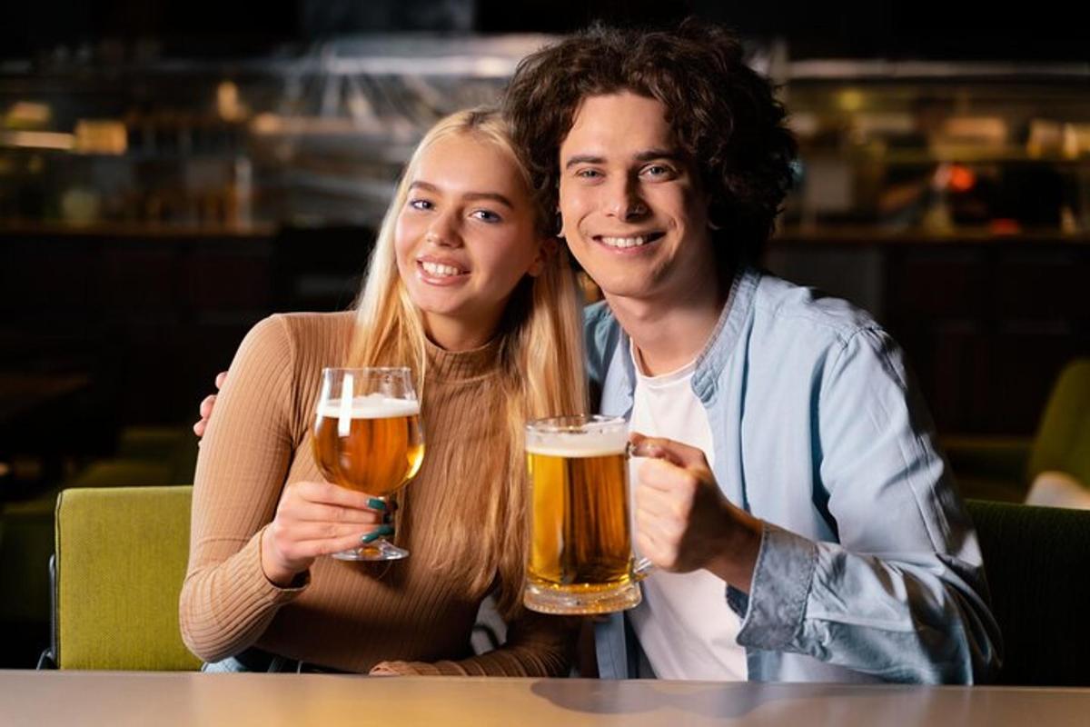 Un hombre y una mujer sosteniendo vasos de cerveza