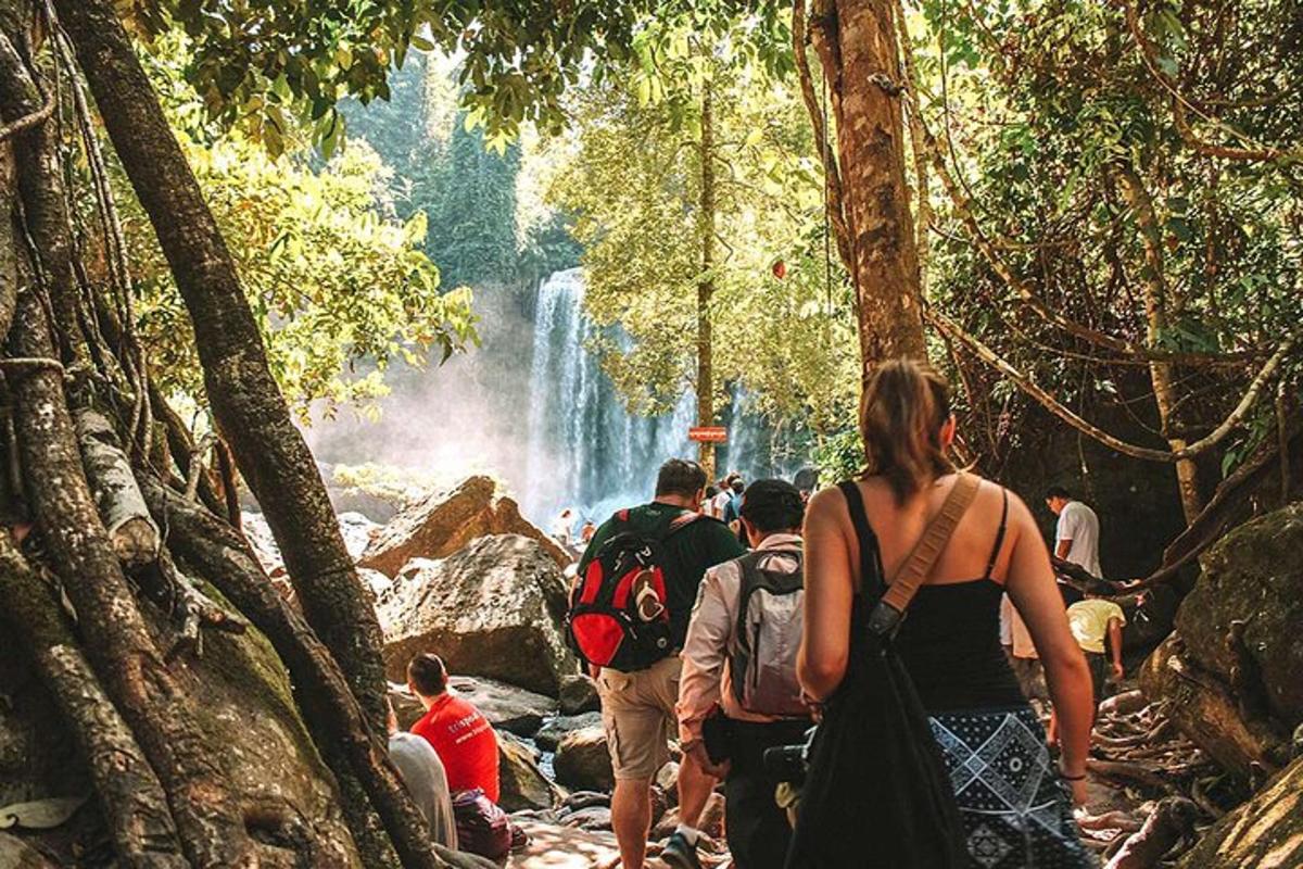 un grup de persones caminant davant d'una cascada