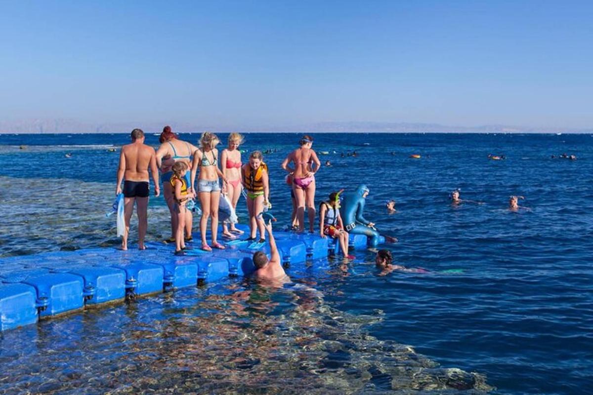 skupina ljudi, ki stojijo na modrih splavih v vodi