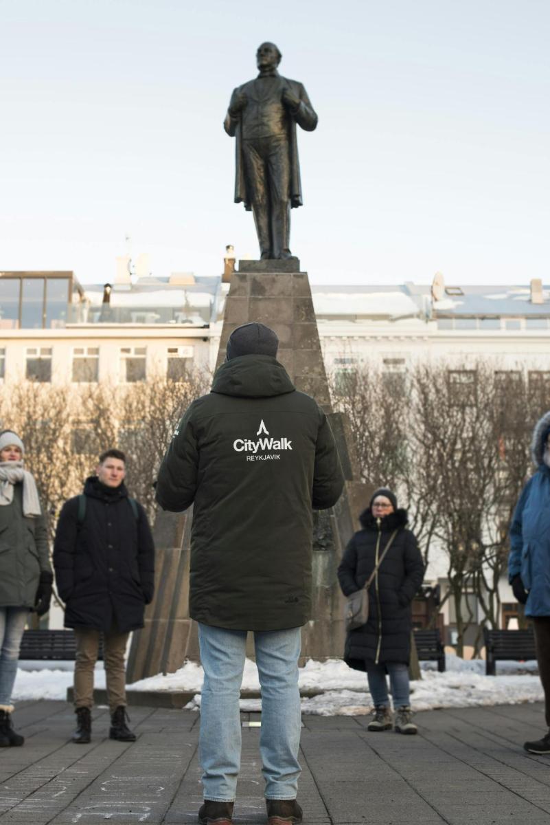 skupina lidí stojících před sochou