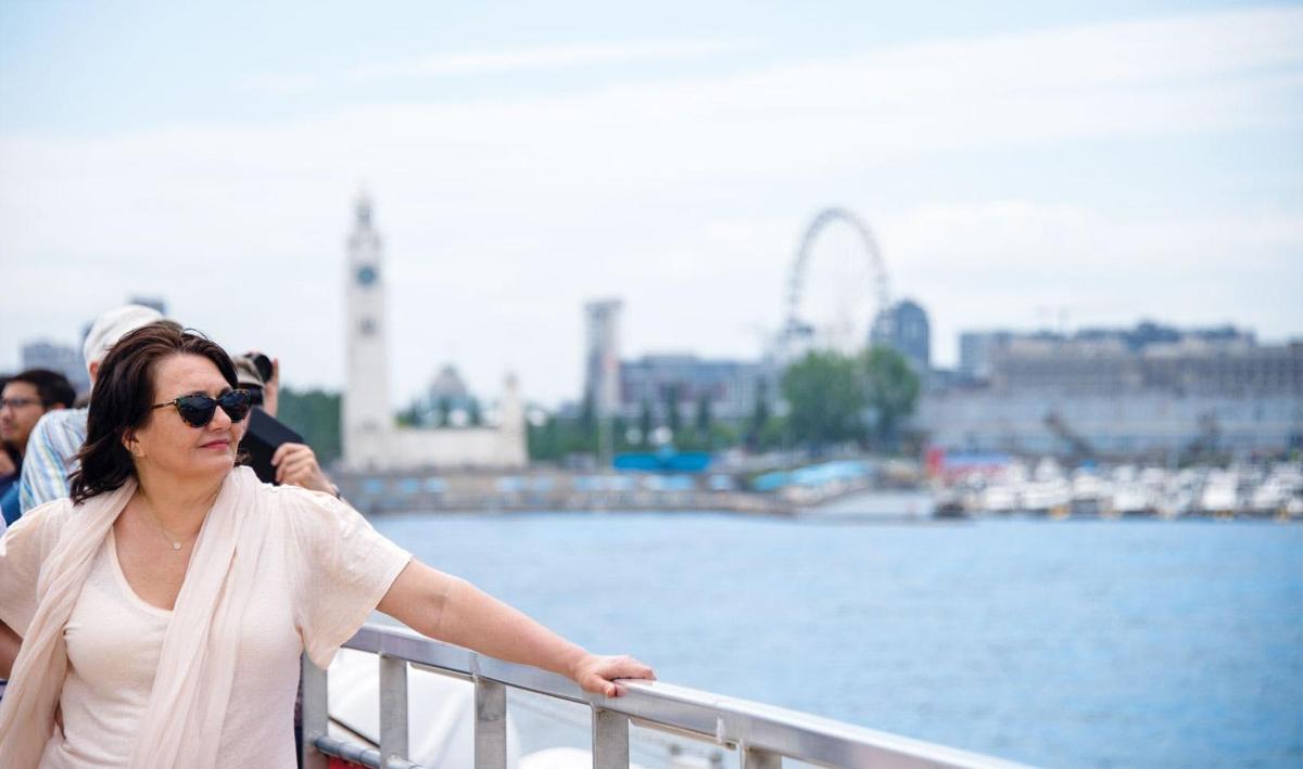 a woman leaning on a railing next to the water