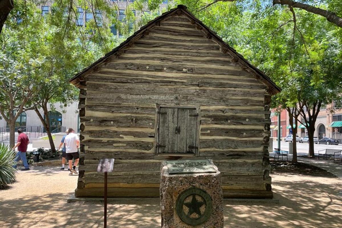 Un pequeño edificio de madera con una puerta en un parque.