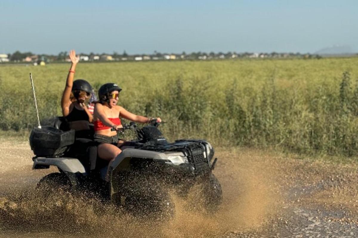 duas mulheres andando em um quadriciclo na água