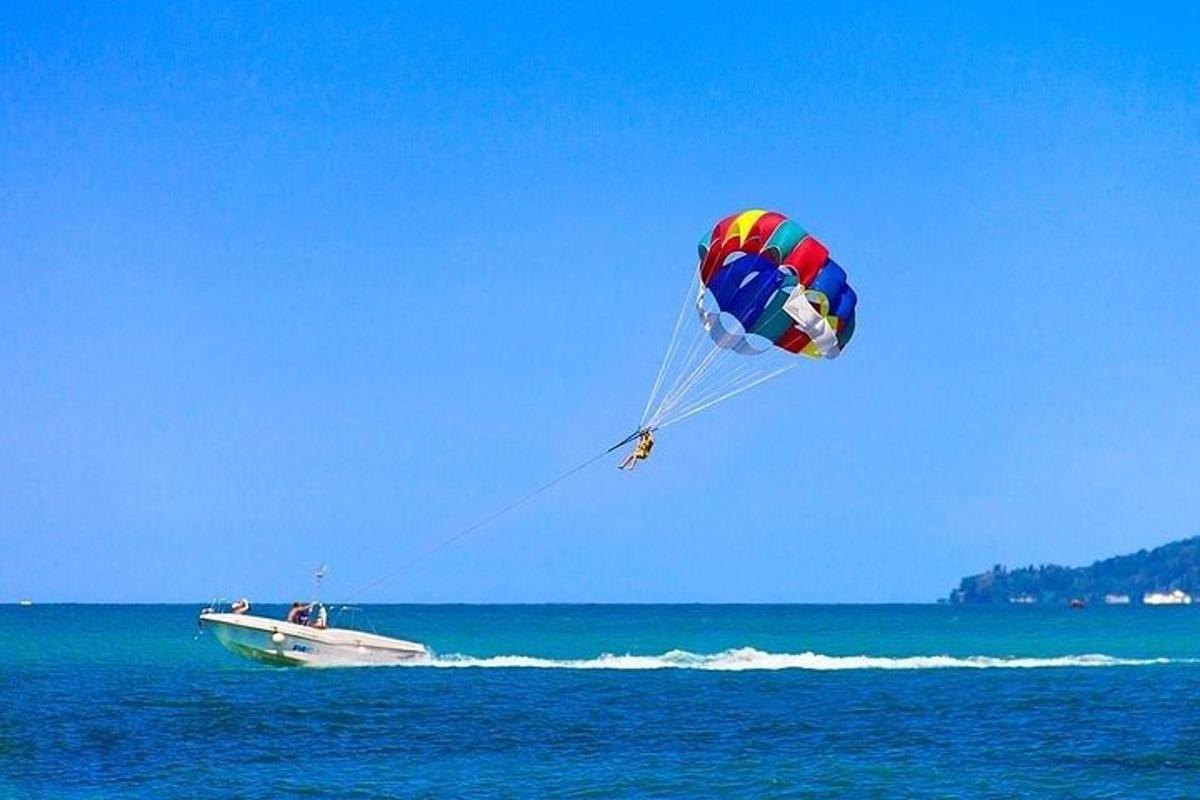 osoba pouštějící draka nad oceánem s lodí