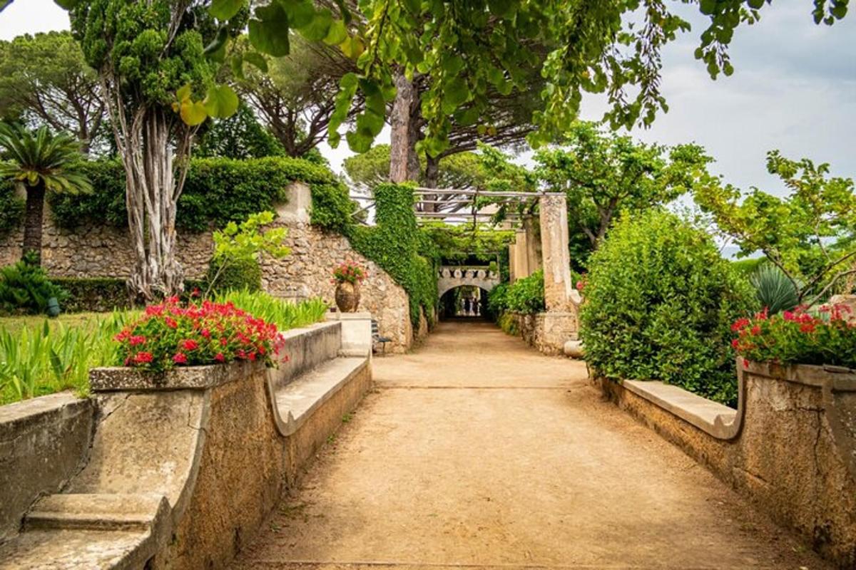 um caminho em um jardim com flores e uma ponte