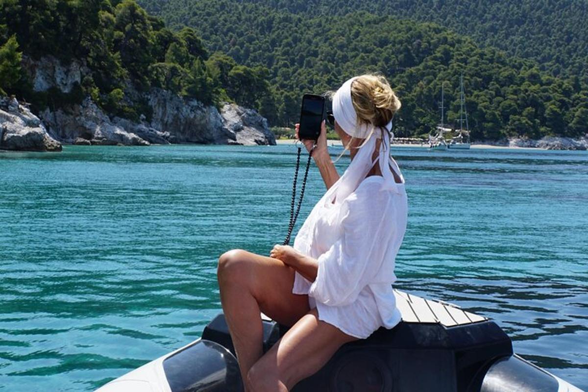 a woman sitting on a boat taking a picture of the water