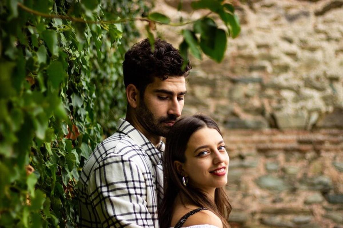 un uomo e una donna in piedi accanto a un muro