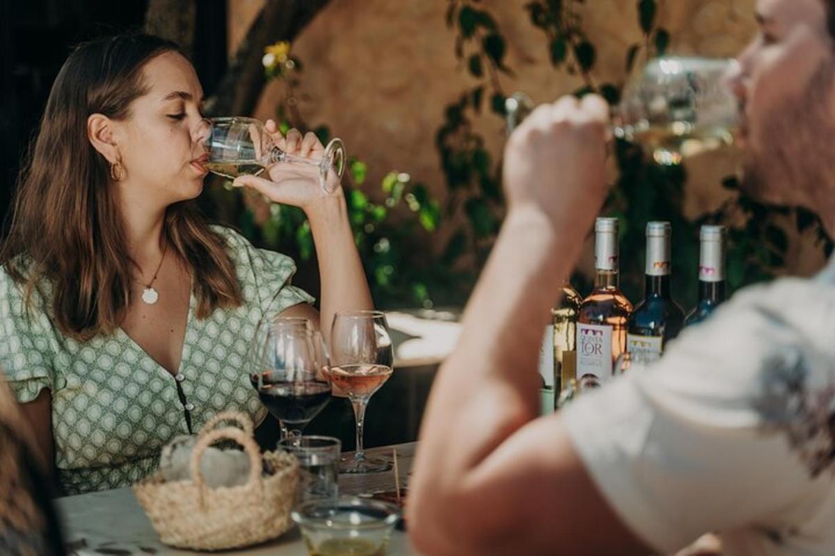 a man and a woman sitting at a table drinking wine