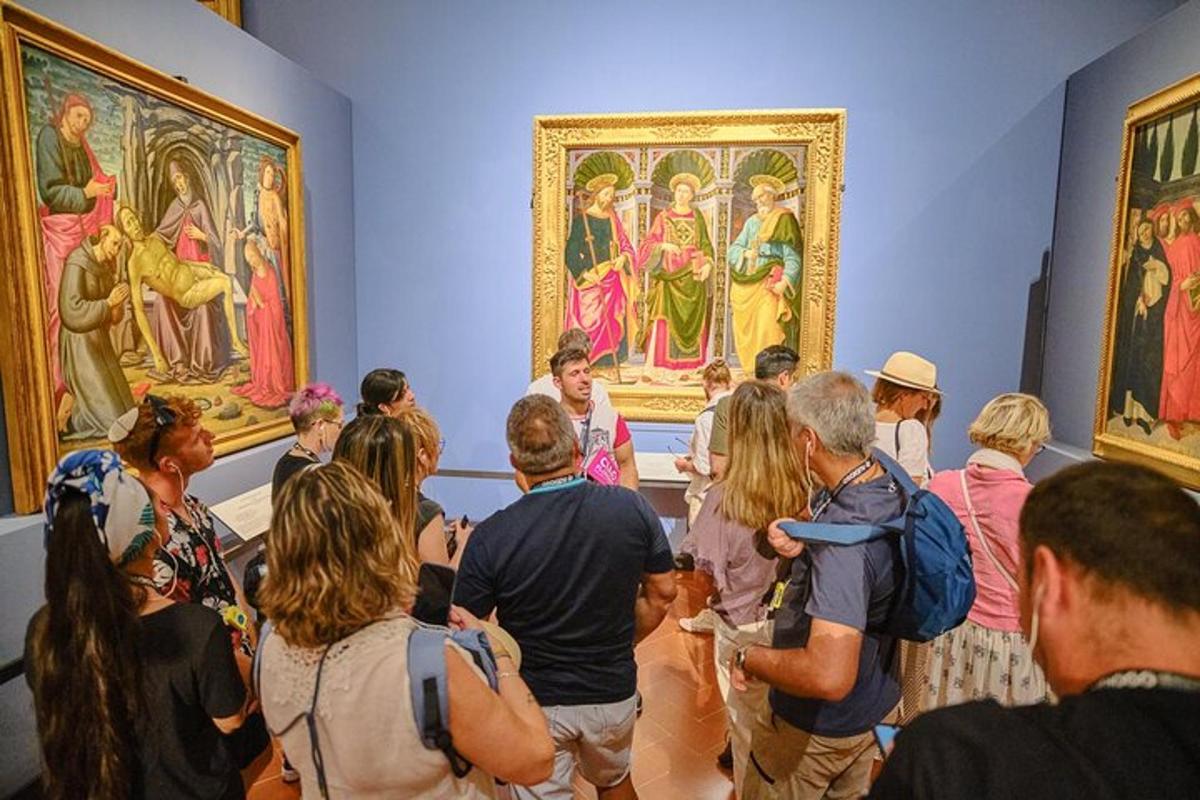 Un grupo de personas mirando pinturas en un museo.