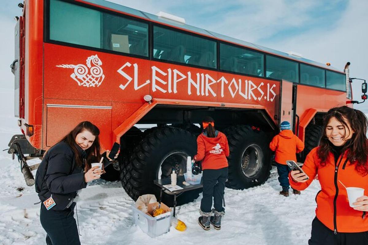 un gruppo di persone in piedi accanto a un autobus nella neve