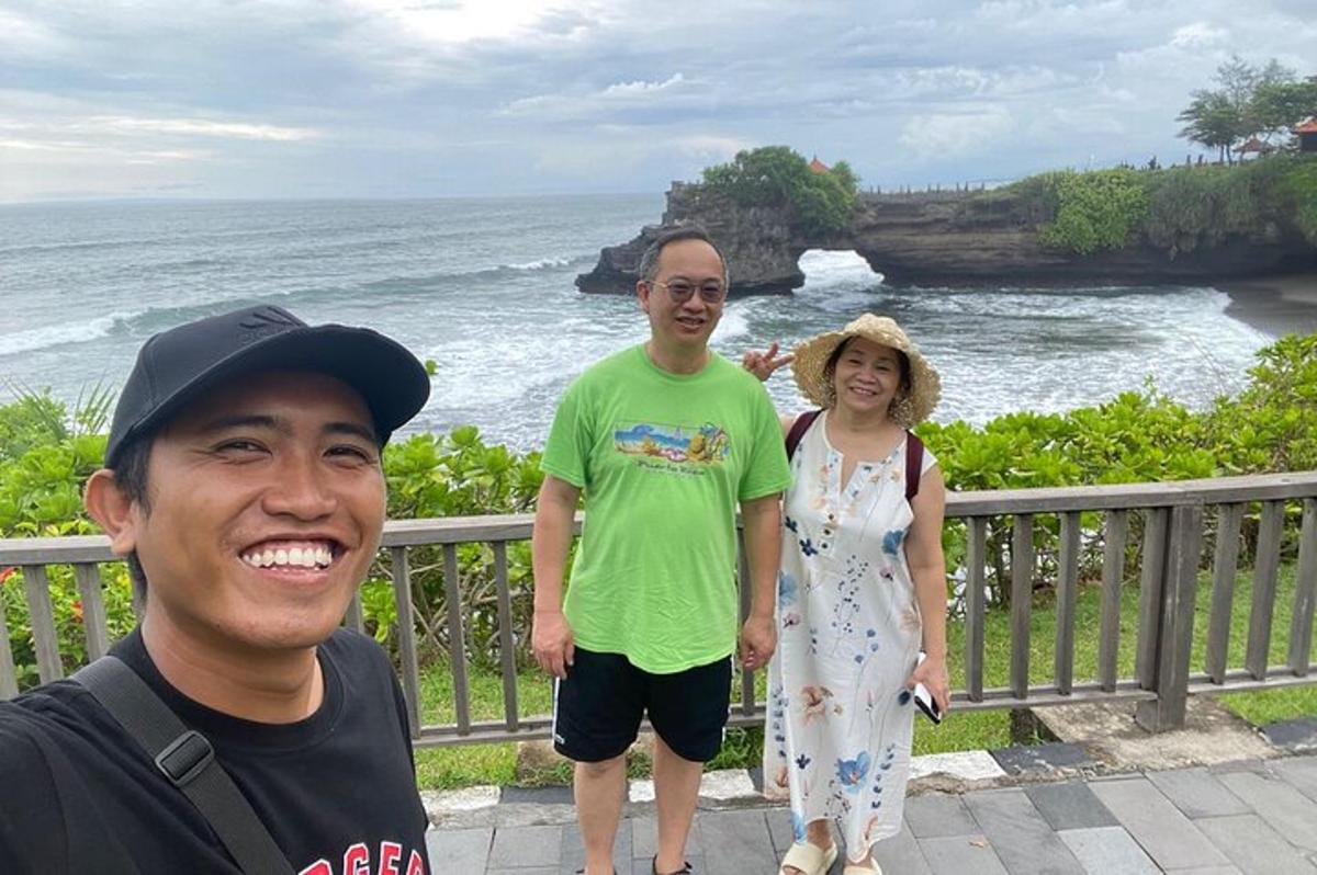 a man and a woman standing next to the ocean
