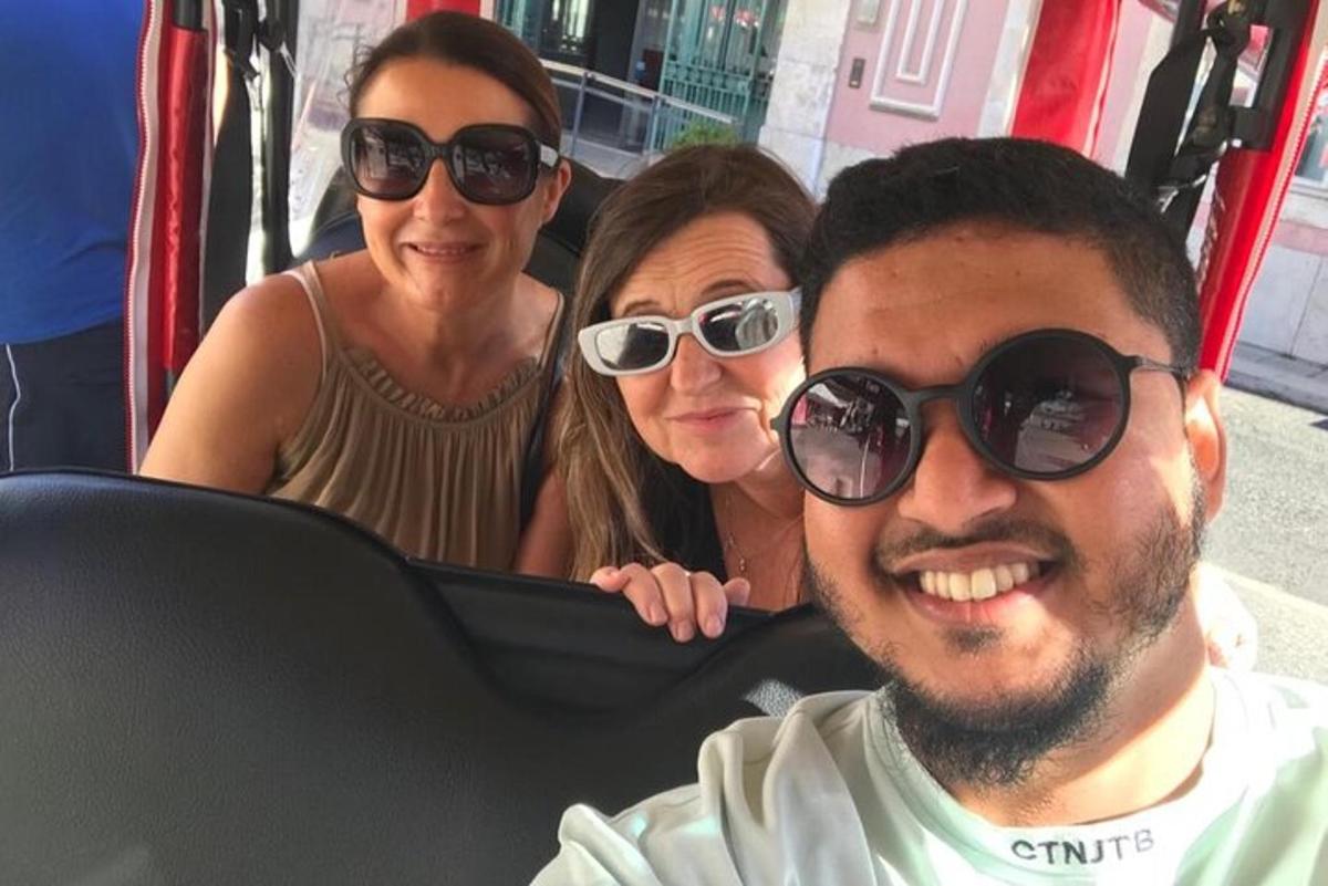 dvě ženy a muž se slunečními brýlemi v autobuse