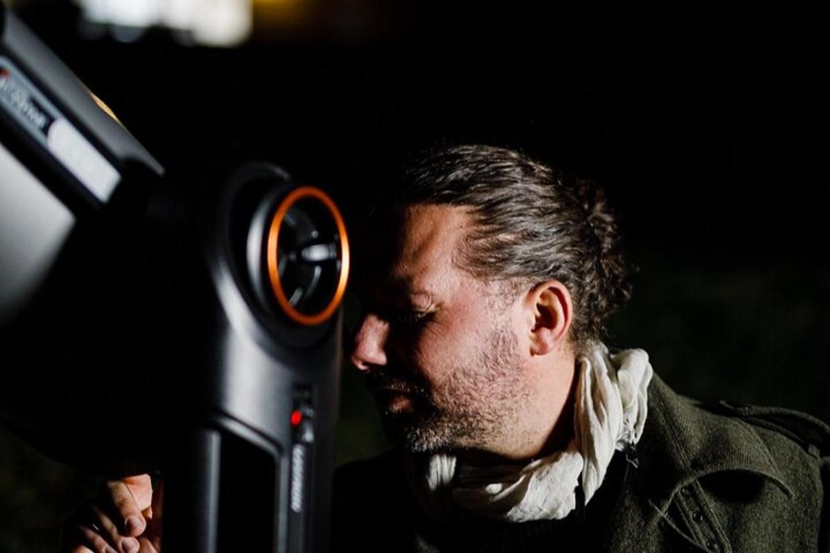 a man is looking through a magnifying glass