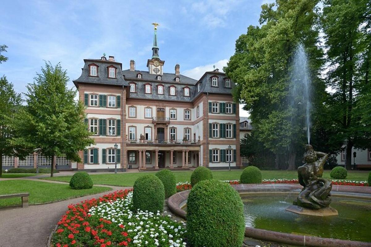 una grande casa con una fontana di fronte