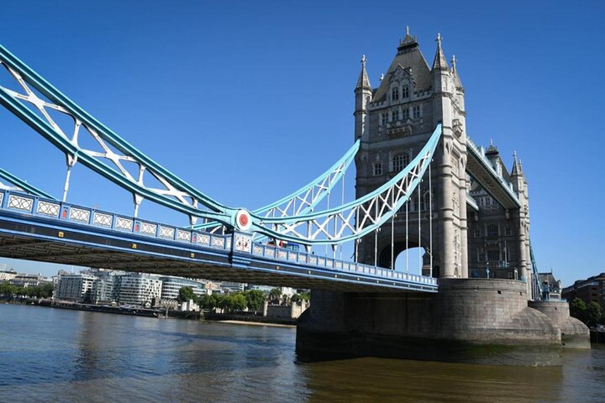 Un puente colgante sobre el agua con un edificio.