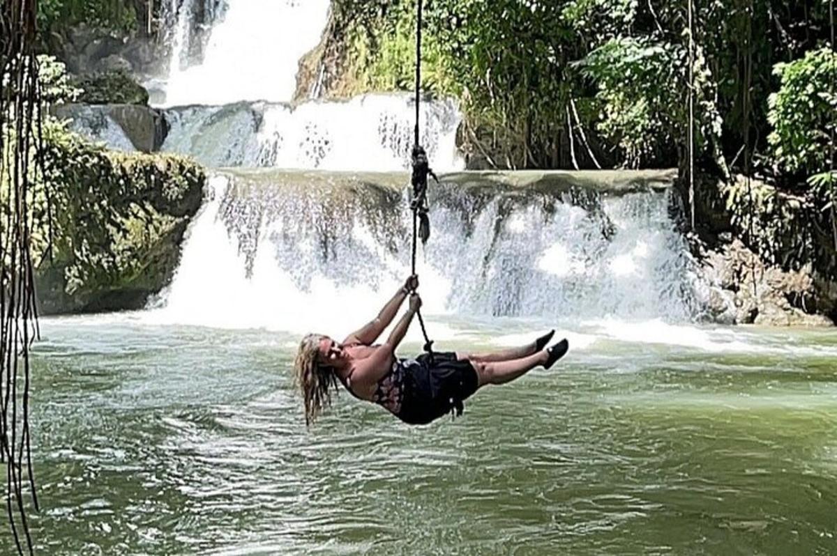 una dona penjada d'una corda davant d'una cascada