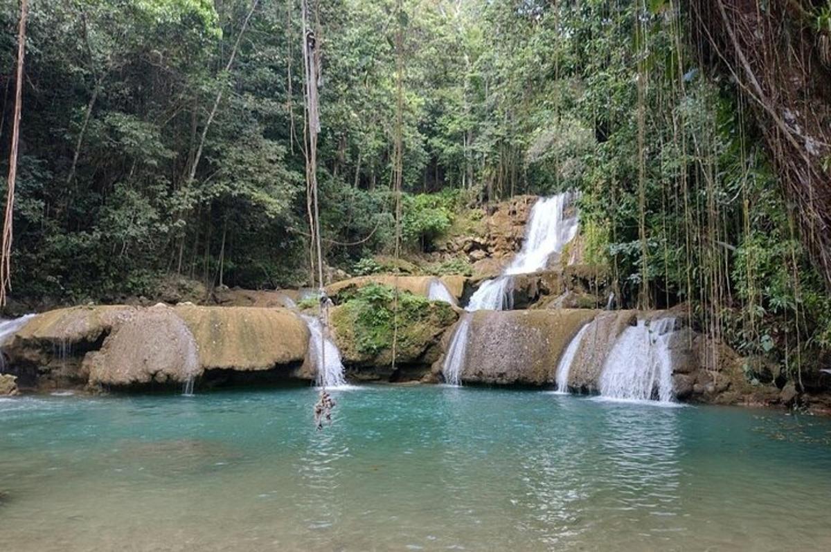 una persona a l'aigua davant d'una cascada