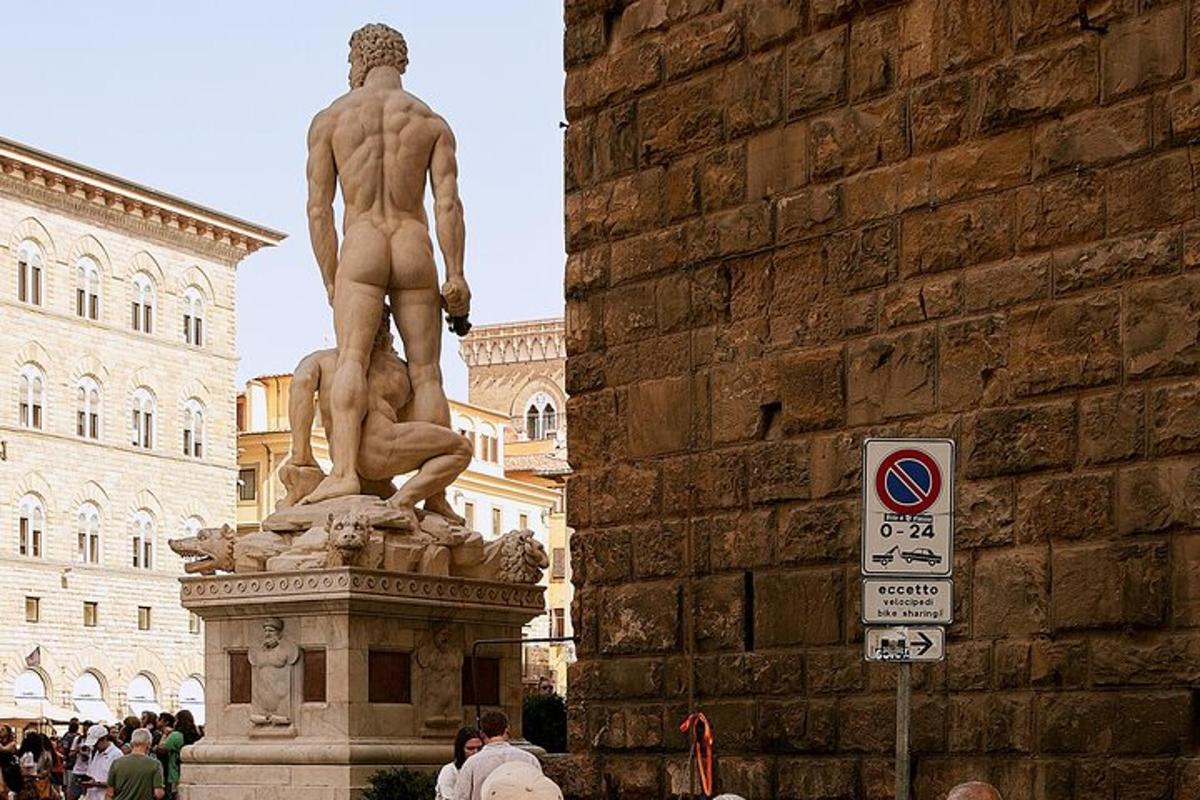 una estàtua d'un home dret al costat d'una paret de maons