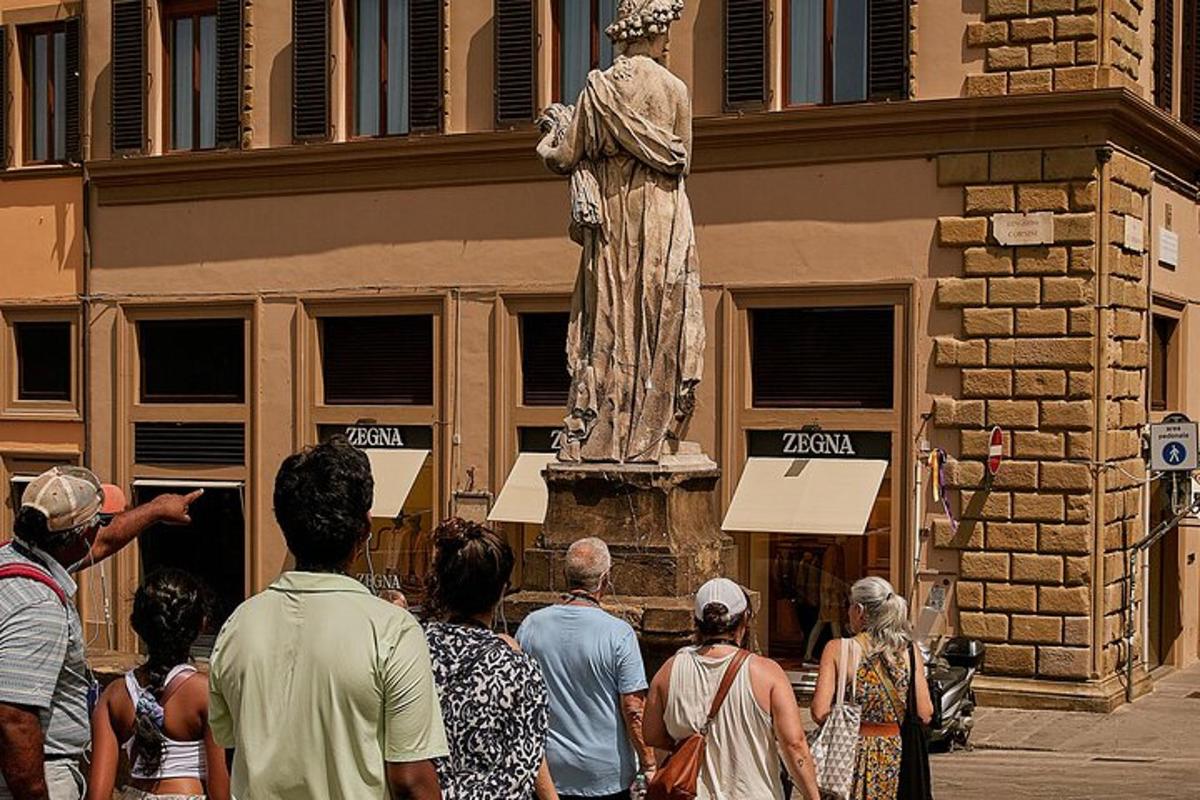 un grup de persones dempeus davant d'una estàtua