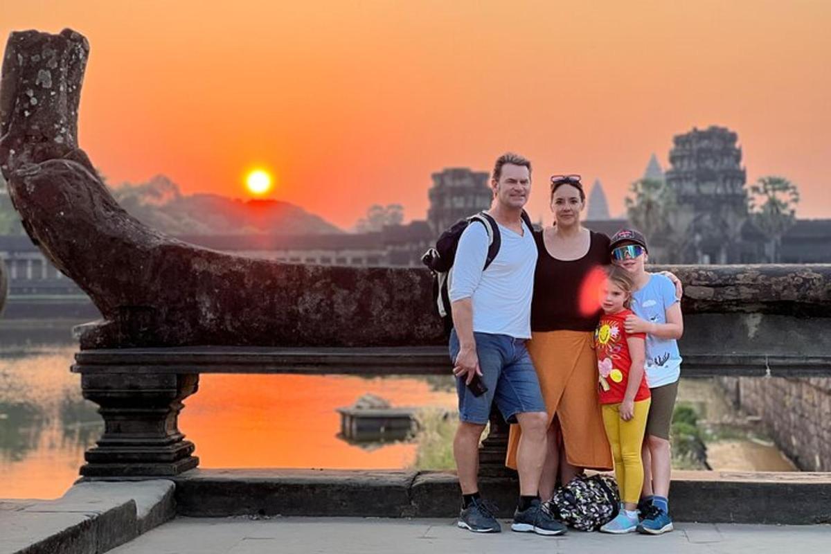 ครอบครัวโพสท่าหน้ารูปปั้นพร้อมพระอาทิตย์ตก