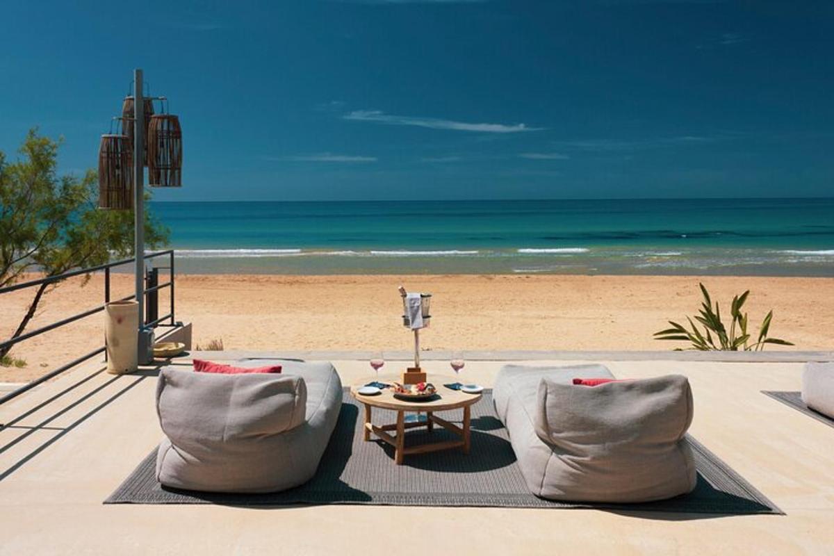 Blick auf einen Strand mit zwei Stühlen und einem Tisch